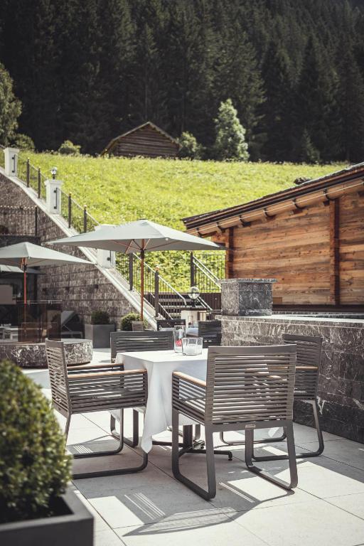 a table with chairs and umbrellas on a patio at Schlosshotel Ischgl 5-Sterne Superior in Ischgl