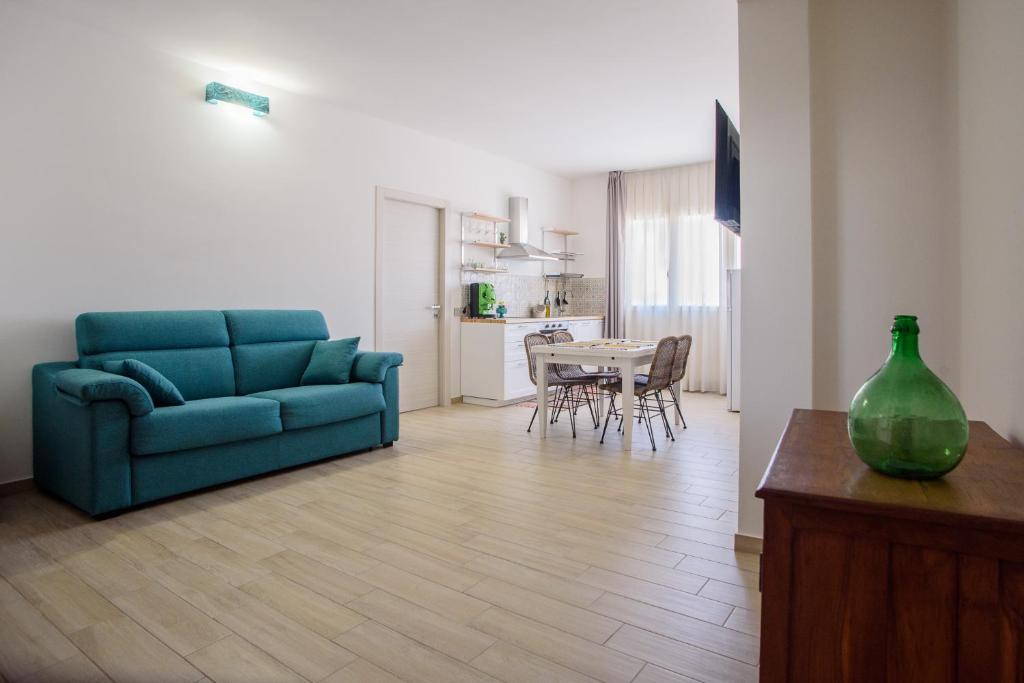 ein Wohnzimmer mit einem blauen Sofa und einem Tisch in der Unterkunft CENTRAL STATION APARTMENTS - Fanale Rentals in Palermo