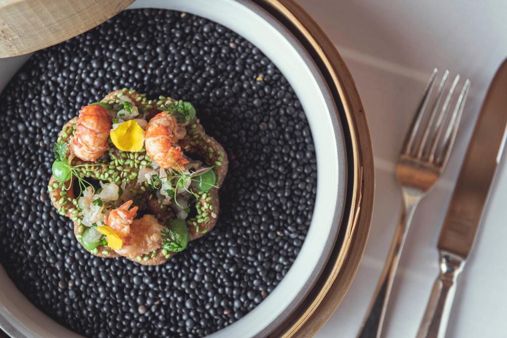a plate of food with shrimp and vegetables on it at Schlosshotel Ischgl 5-Sterne Superior in Ischgl