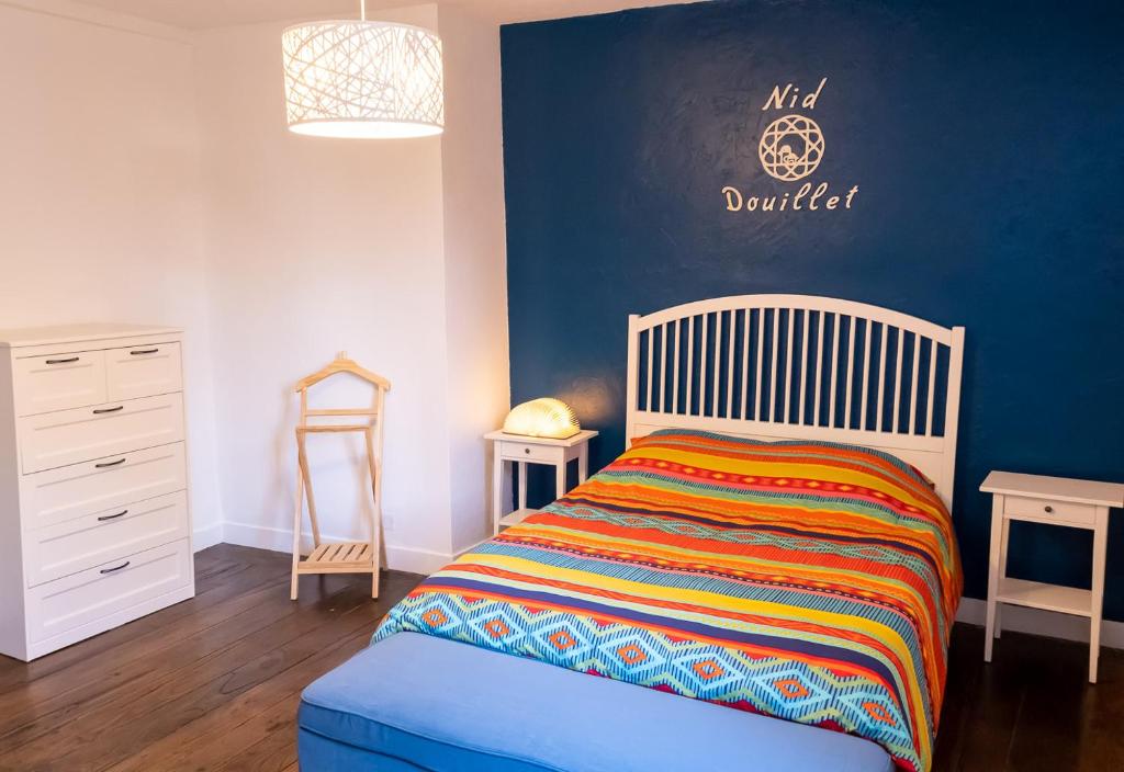 une chambre avec un lit et un mur bleu dans l'établissement Appartement Saint-Sauveur, à Dinan
