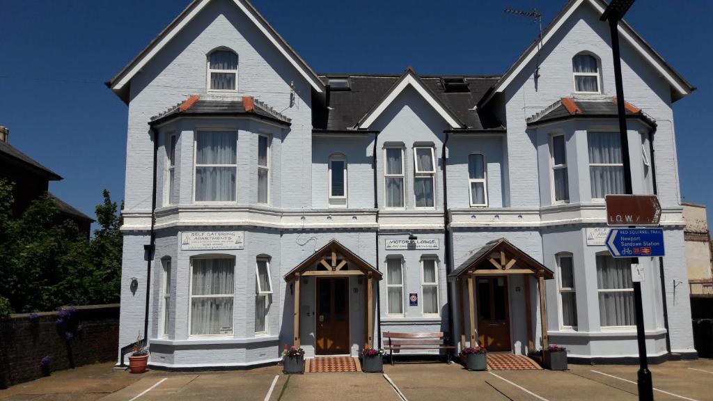 uma grande casa branca com duas portas numa rua em Victoria Lodge em Sandown