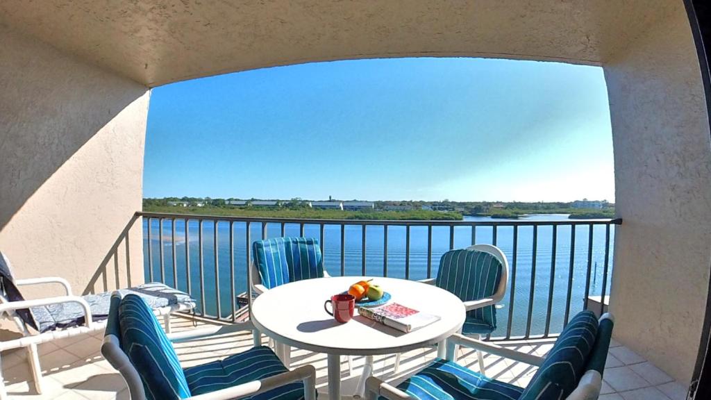 a balcony with a table and chairs and a view of the water at Sea Club Condo #304 in Clearwater Beach