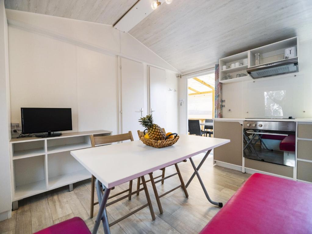 a kitchen and dining room with a table and chairs at Camping Paradis 4 étoiles Au Port de L'Houmeau - La Rochelle in LʼHoumeau