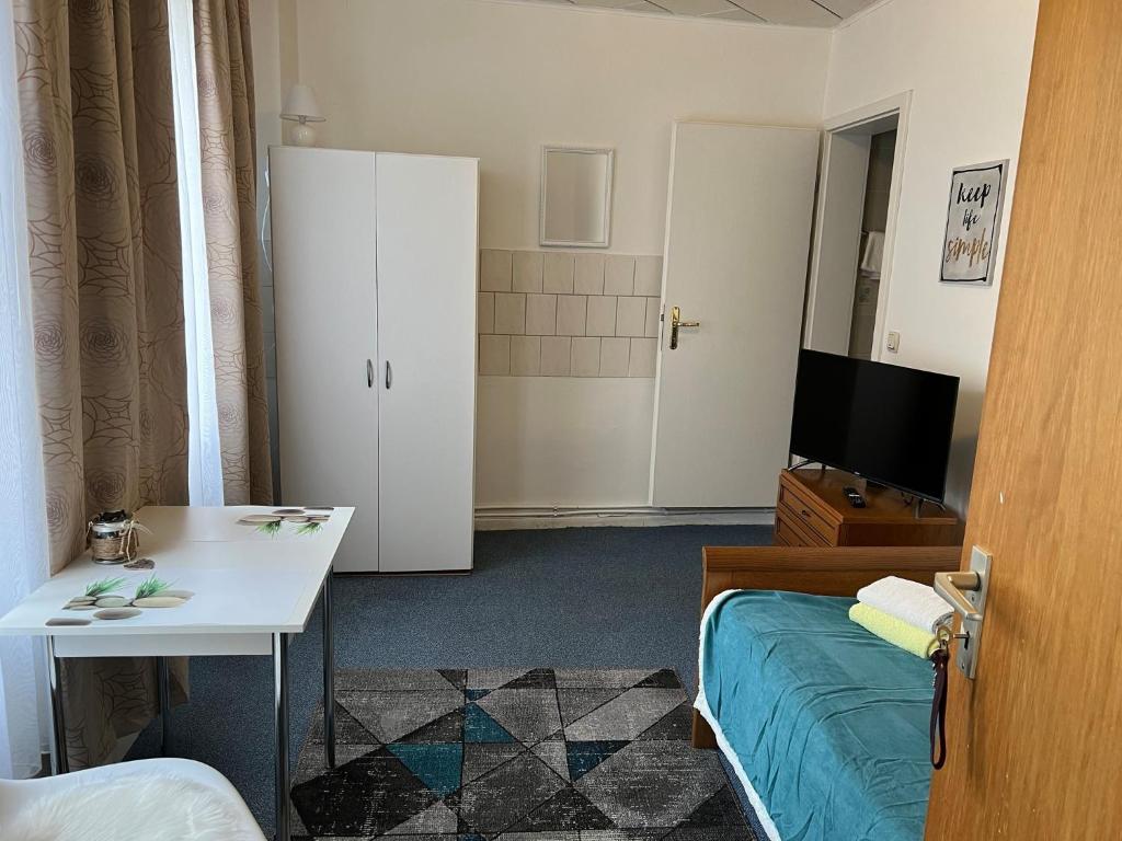 um quarto com uma cama, uma secretária e uma televisão em Ferienappartements Dolgesheim 3 em Dolgesheim