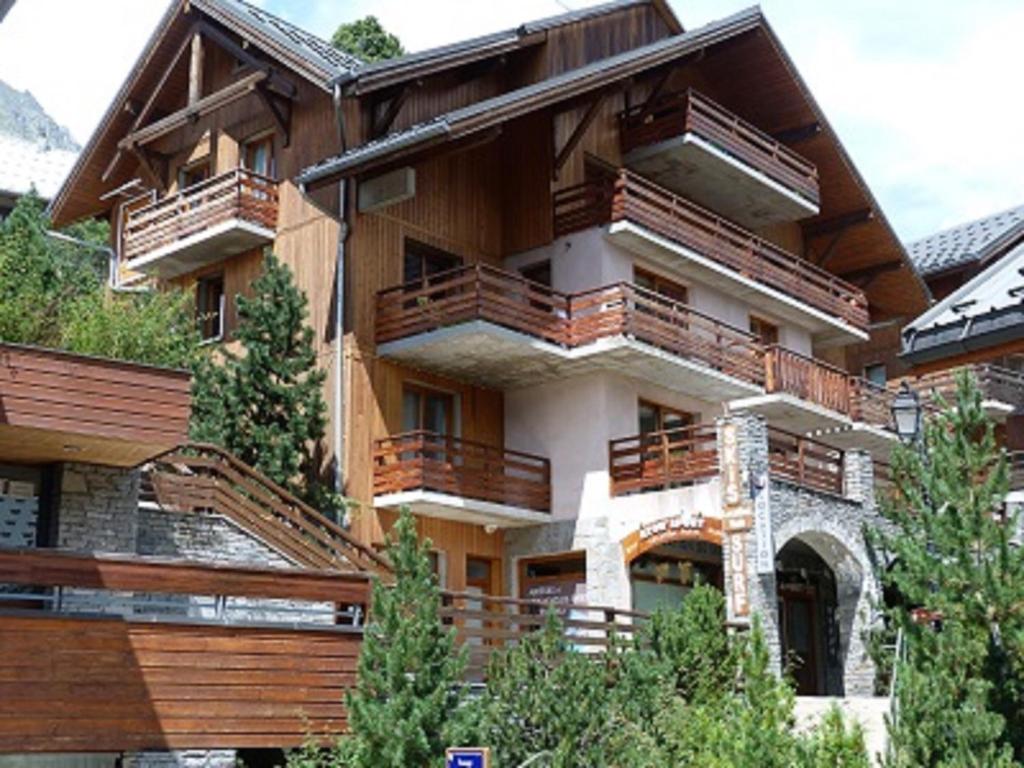 a building with wooden balconies on the side of it at Les Balcons de Vaujany in Vaujany