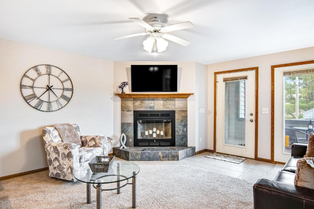 a living room with a fireplace and a ceiling fan at Lighthouse Cove Condo Resort in Wisconsin Dells