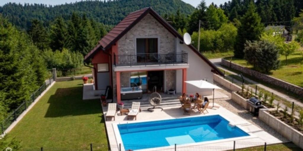 an aerial view of a house with a swimming pool at Gorska Vila Lokvarsko jezero in Lokve