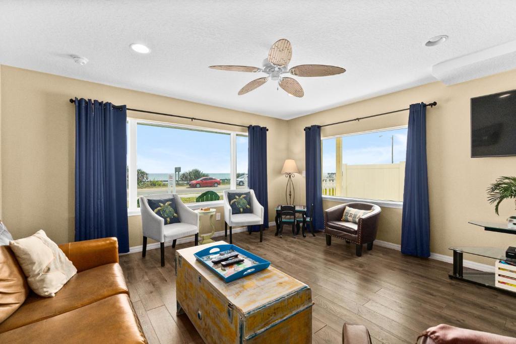 a living room with a couch and a ceiling fan at Pier Watch in Flagler Beach