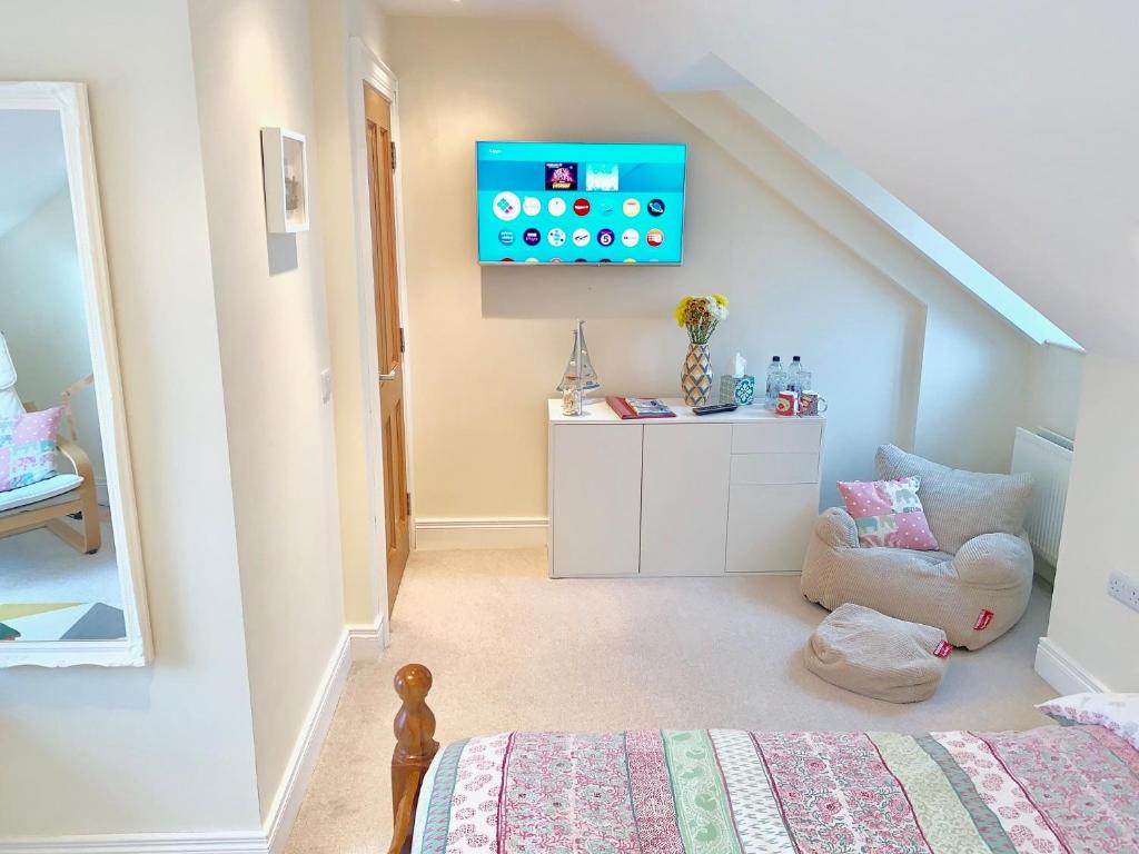 a bedroom with a bed and a tv on the wall at Loft Room @ Sean and Janes in Ballycastle