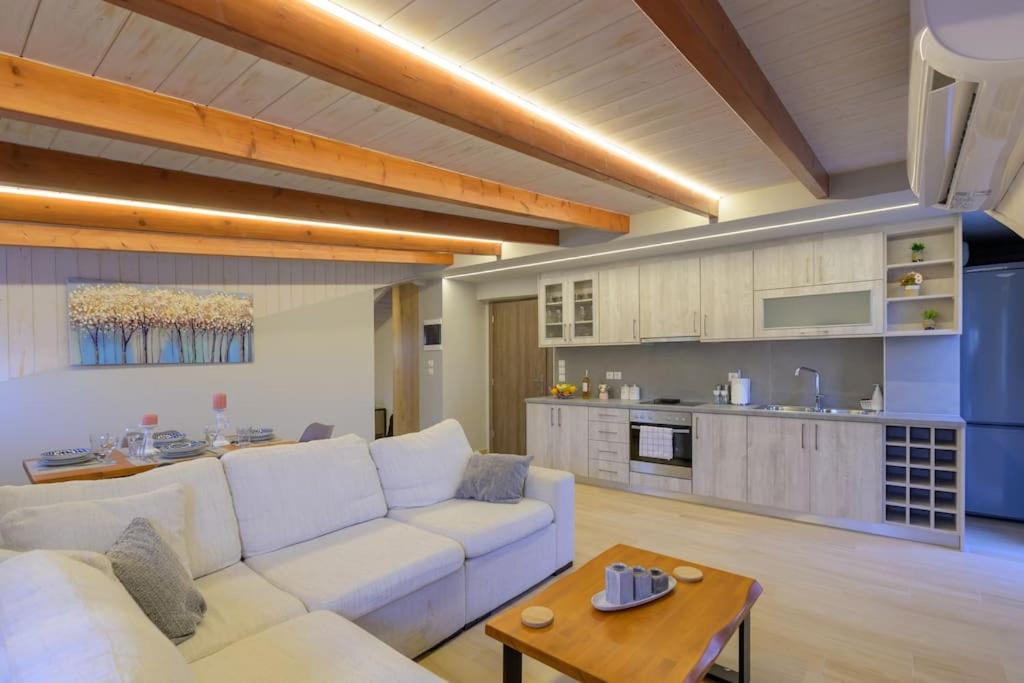 een woonkamer met een witte bank en een keuken bij Contemporary Attic in Preveza