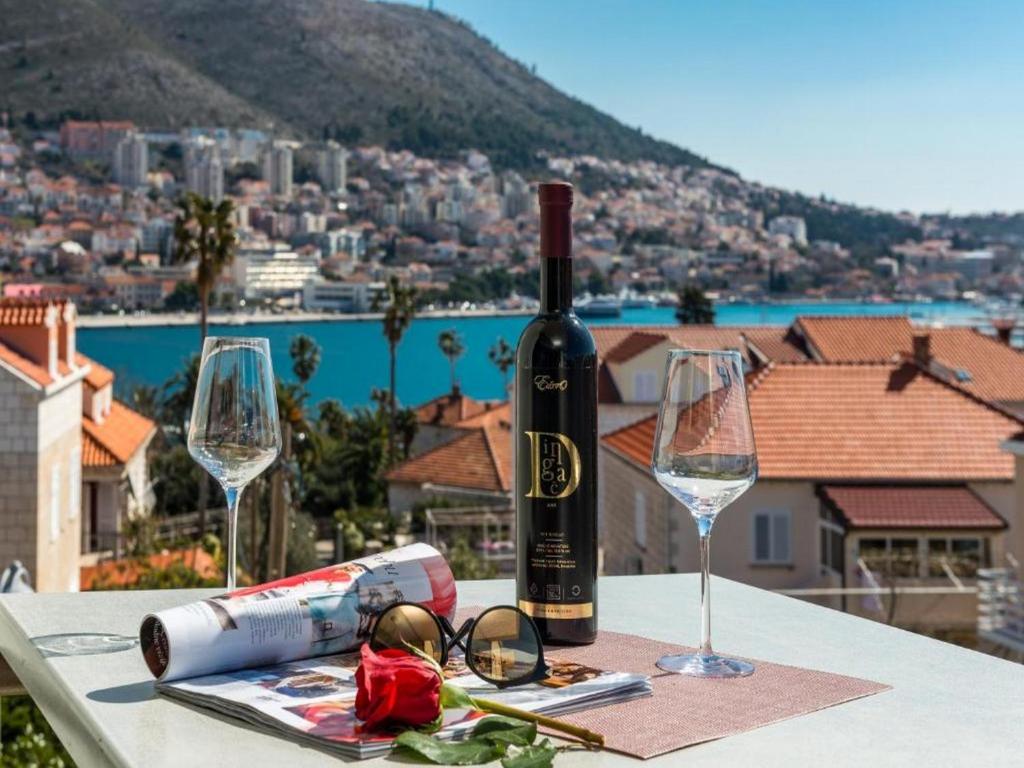a table with a bottle of wine and two glasses at Apartment Corto Maltese in Dubrovnik