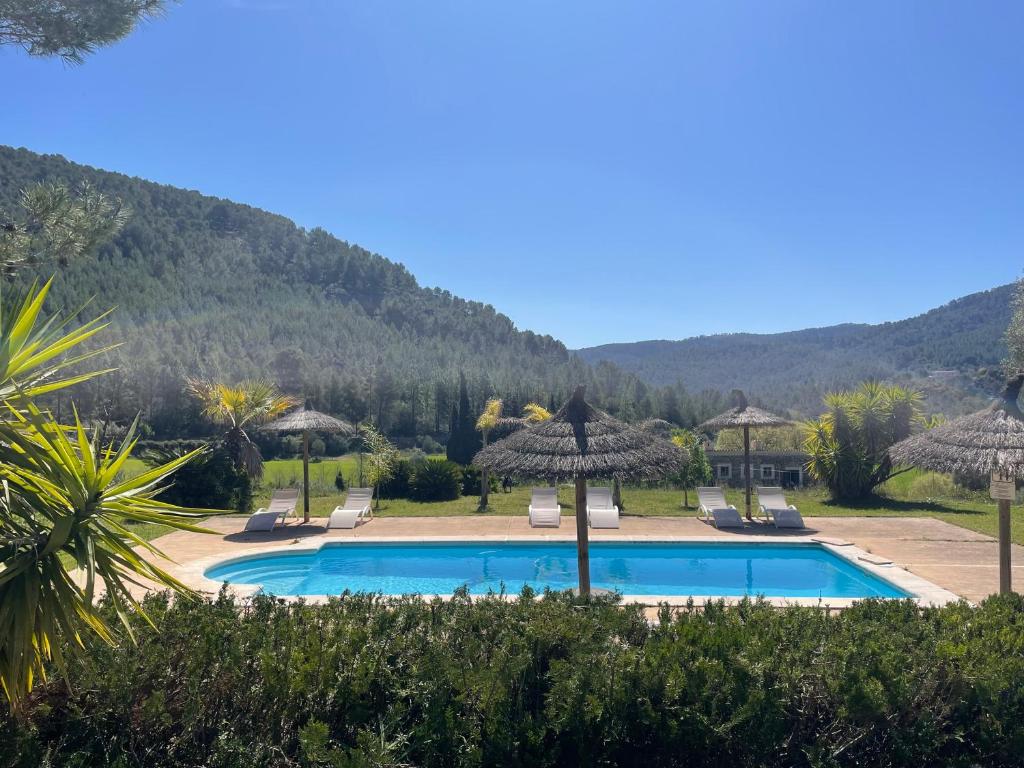 a resort with a swimming pool and mountains in the background at Finca Son Pont in Puigpunyent