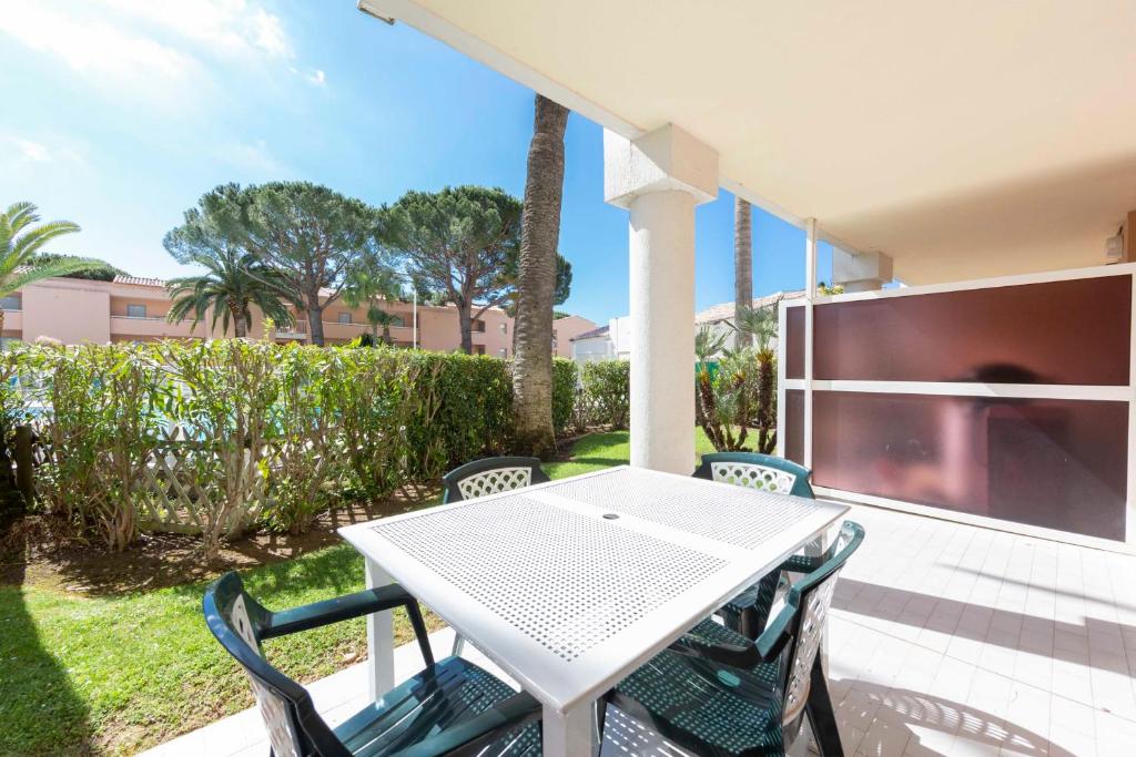 a white table and chairs on a patio at 1 bedroom apartment in a residence with a swimming pool and a parking spot in Vallauris