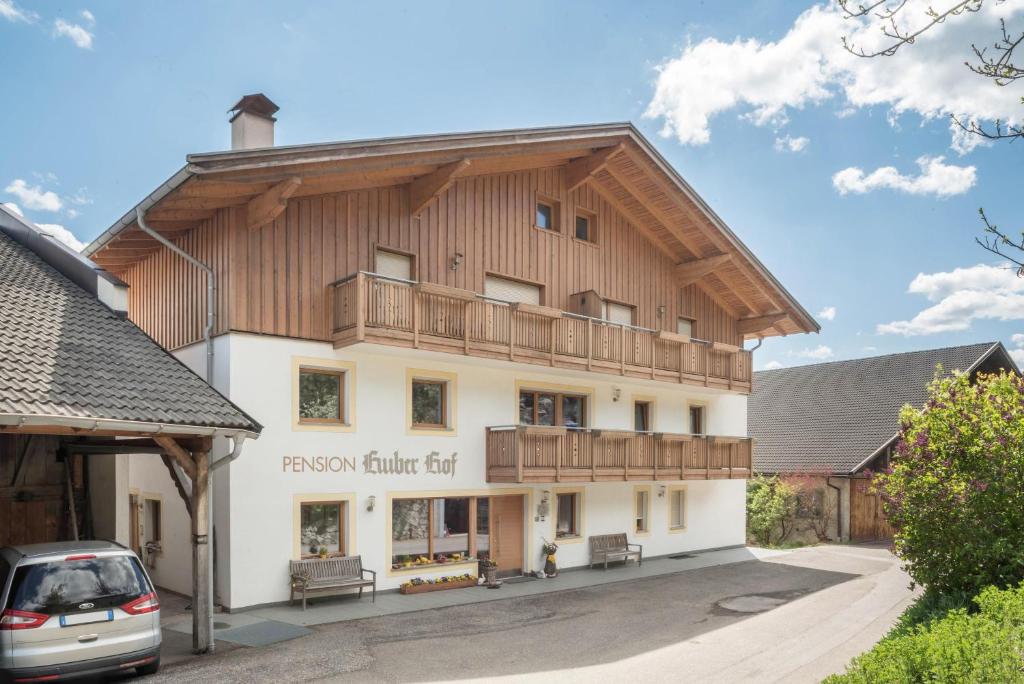duży drewniany budynek z balkonem w obiekcie Huberhof App Gala w mieście Feldthurns