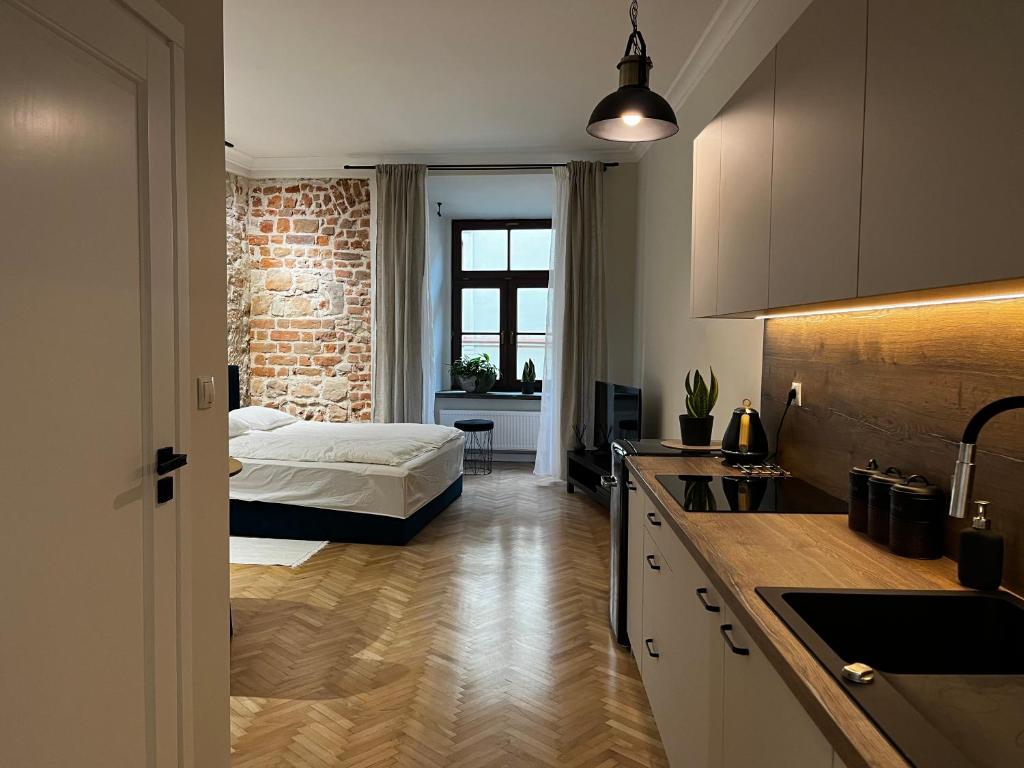 uma cozinha e um quarto com uma cama num quarto em Apartamenty Rynek 5 em Lublin