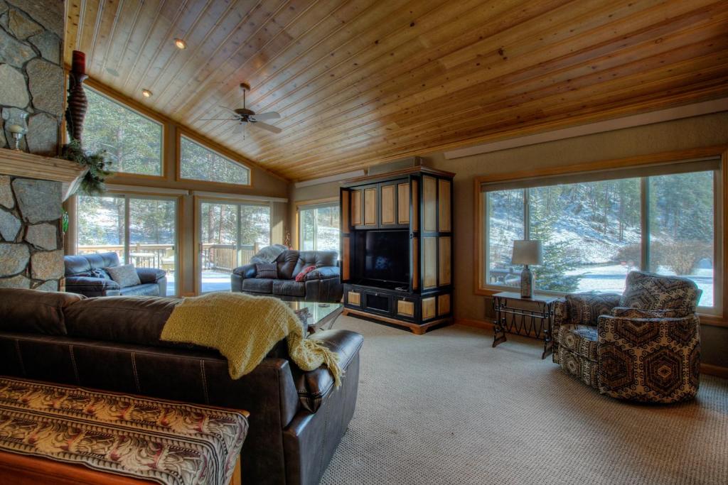 uma sala de estar com um sofá e uma televisão e algumas janelas em Rapid Creek Lodge em Rapid City