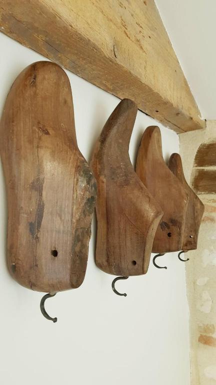 a pair of wooden utensils hanging on a wall at NAMASTE COTTAGE in Issigeac