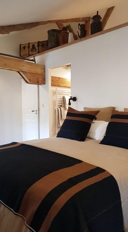 a bedroom with a bed with a black and white blanket at NAMASTE COTTAGE in Issigeac
