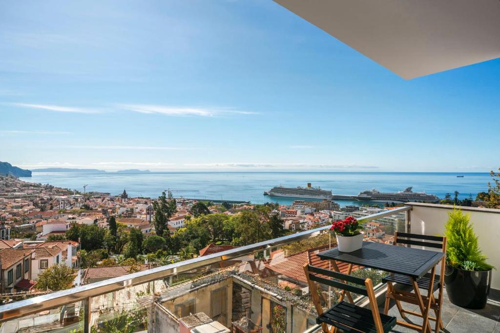 a balcony with a table and chairs and the ocean at Casa do Castelo by An Island Apart in Funchal
