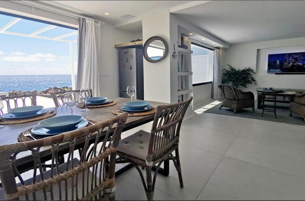 - une salle à manger avec une table et une vue sur l'océan dans l'établissement Villa Luz y Mar, à Guatiza