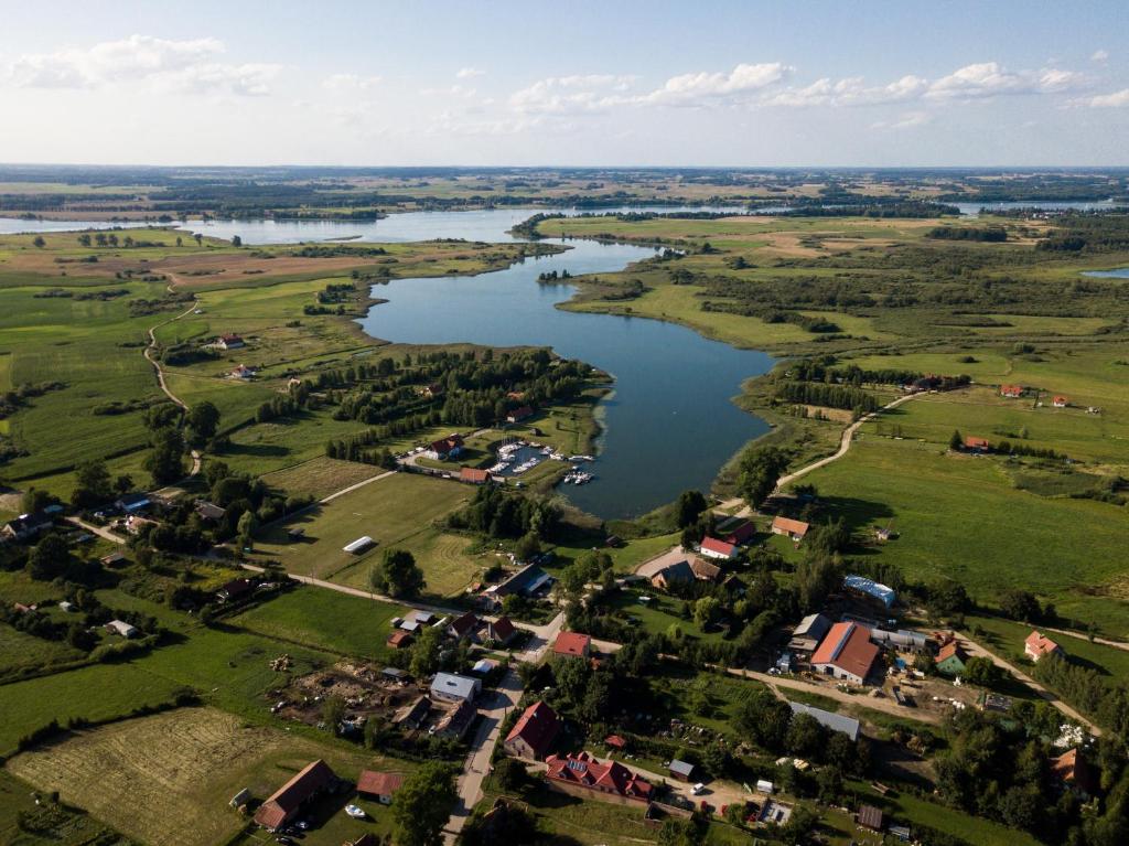 an aerial view of a village next to a river at WIEJSKI APARTAMENT W DOMU NAD JEZIOREM in Mikołajki