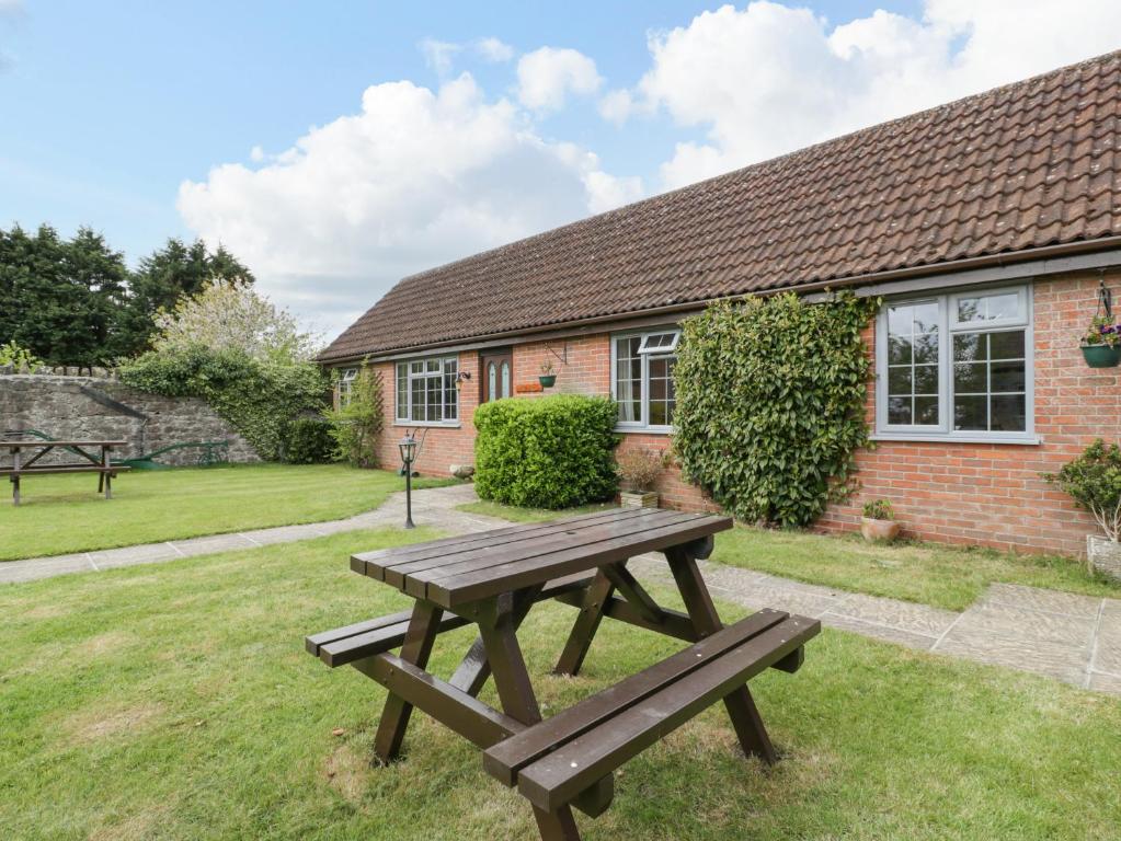 a wooden picnic table in front of a house at Owls Retreat in Weston-super-Mare