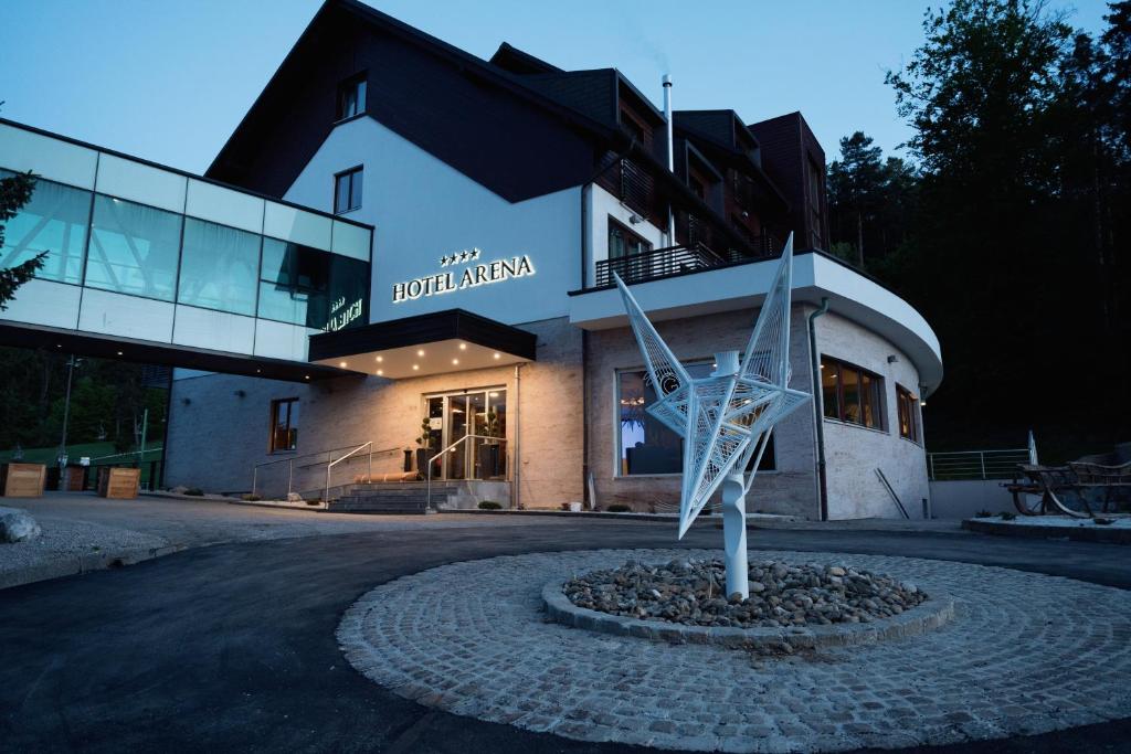 un bâtiment avec une sculpture devant lui dans l'établissement Hotel Arena Maribor, à Maribor