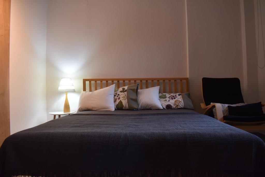 ein Schlafzimmer mit einem Bett mit Kissen und einem Stuhl in der Unterkunft Studio2 in Katerini in Kateríni