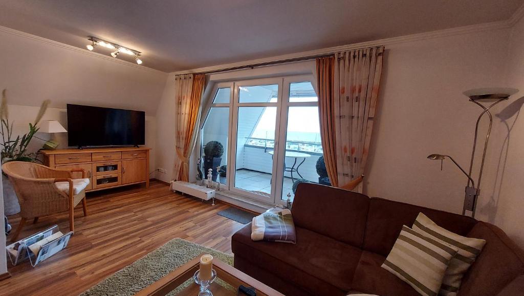 a living room with a couch and a large window at Ferienwohnung Hafenblick in Wiek auf Rügen 