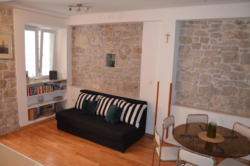 een woonkamer met een zwarte bank en een tafel bij DoLa Split in Split