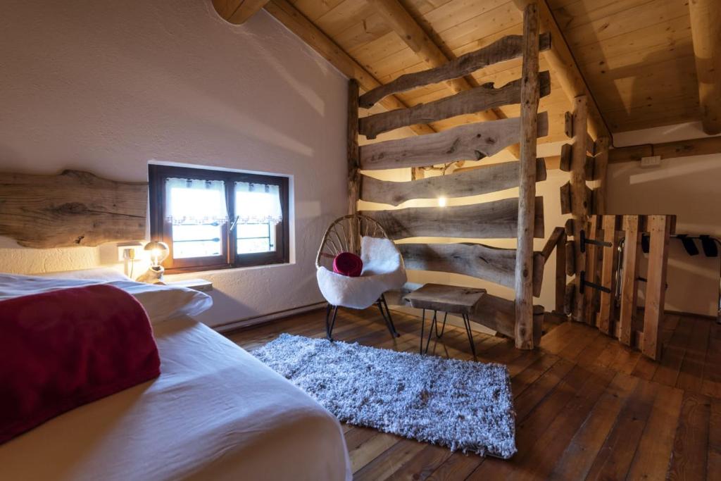 a bedroom with a bed and a chair and a window at Casa Vacanza Ca' de l'elmo in Castello dellʼAcqua