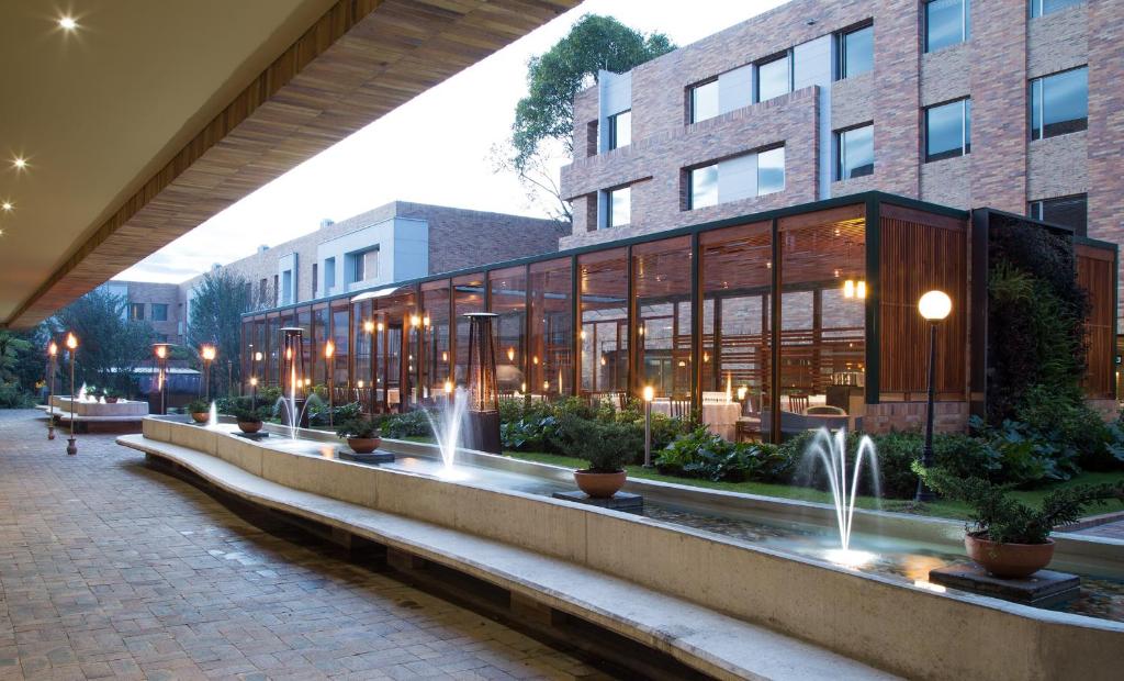 a building with a fountain in front of it at Hotel Habitel Select in Bogotá