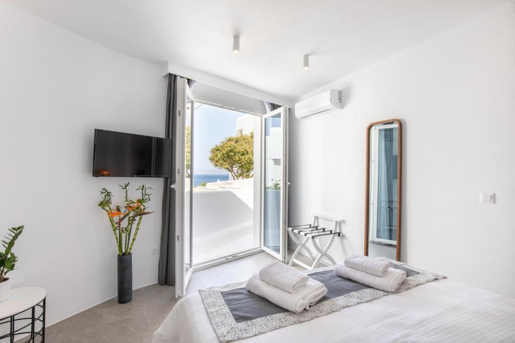 a bedroom with a bed and a large window at Mytheo in Mikonos