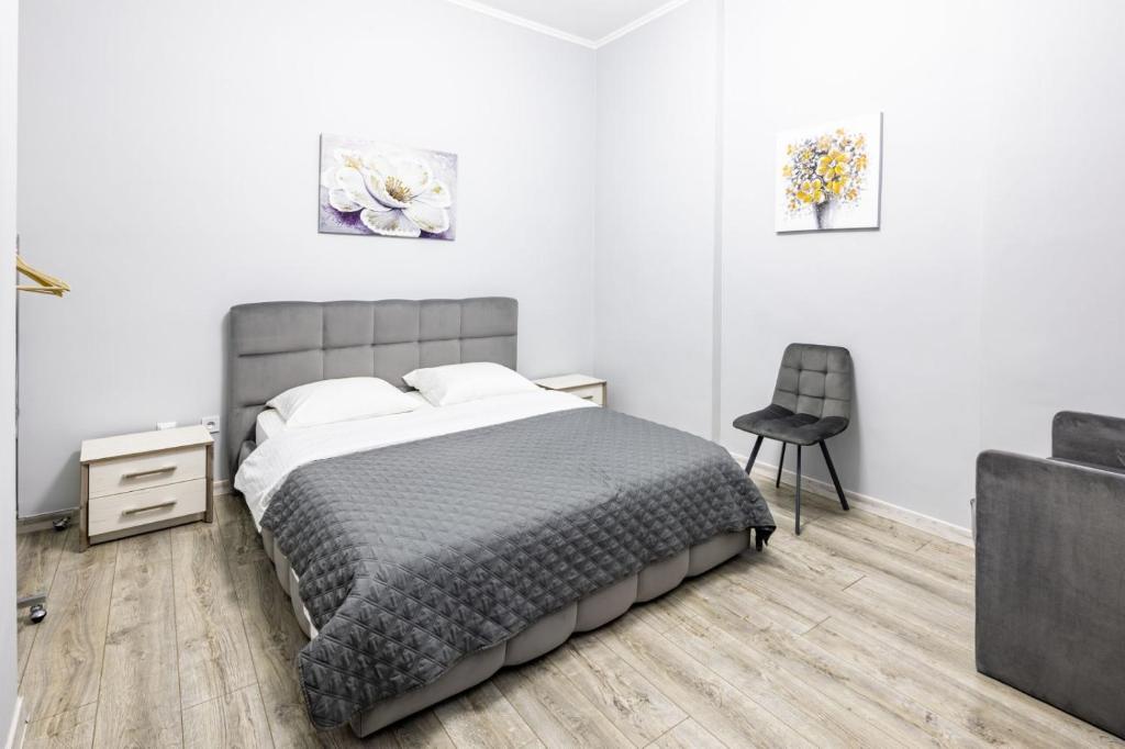 - une chambre avec un lit et une chaise dans l'établissement Apartments Galitskaya street, à Lviv