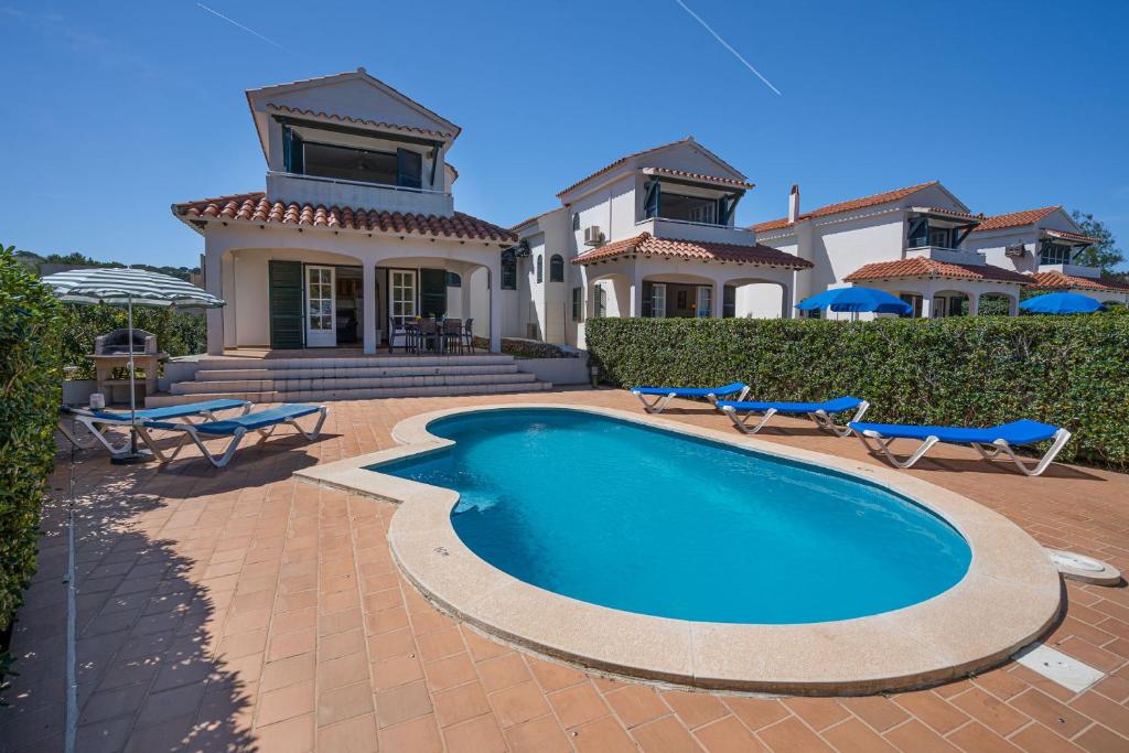 una casa con piscina frente a una casa en Villa LAS MARINAS - 4, con piscina privada y a 5 minutos de la playa en Arenal d'en Castell