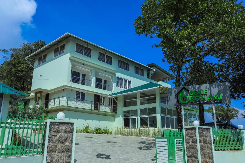 a white building with a sign in front of it at Belle Bonami Resort in Vagamon