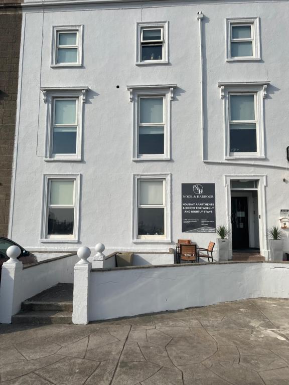 a white building with a sign in front of it at Nook and Harbour Holiday Apartments & rooms in Weston-super-Mare