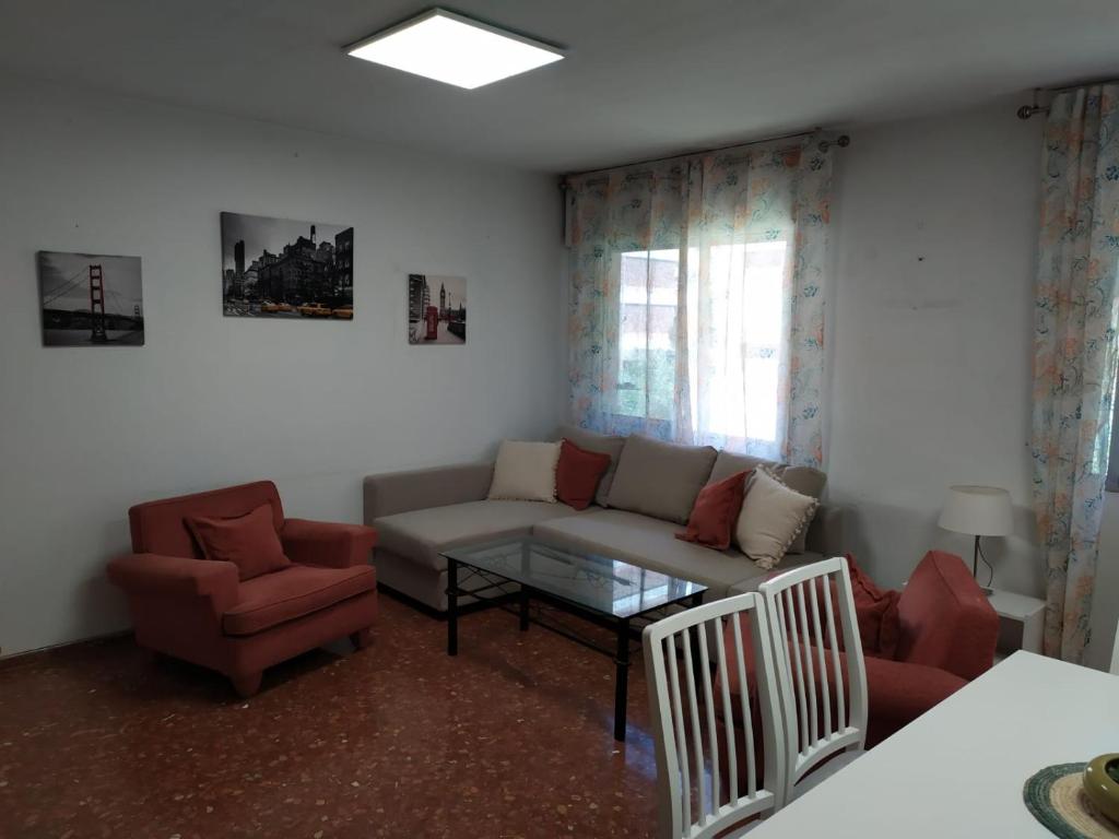 uma sala de estar com um sofá e duas cadeiras em Céntrico apartamento junto al casco histórico em Córdoba