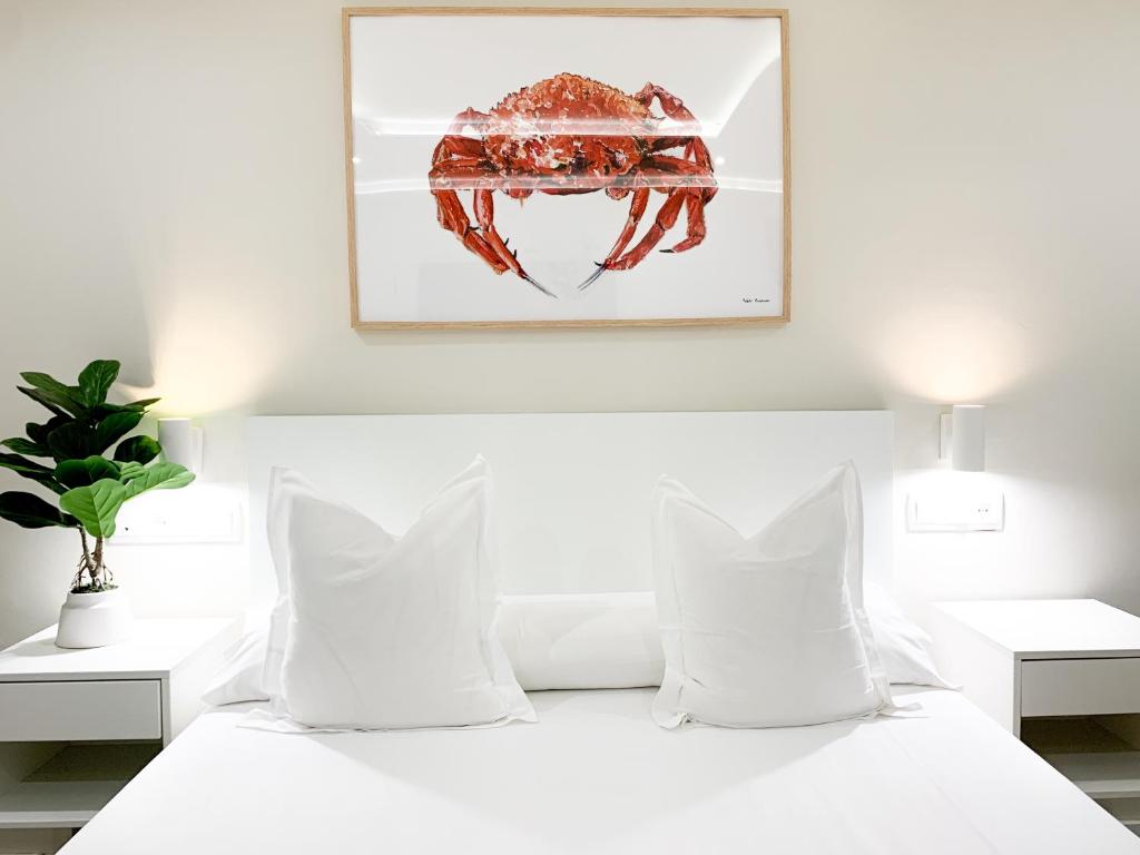 a white bed with white pillows and a picture on the wall at Hotel Celta in Vigo