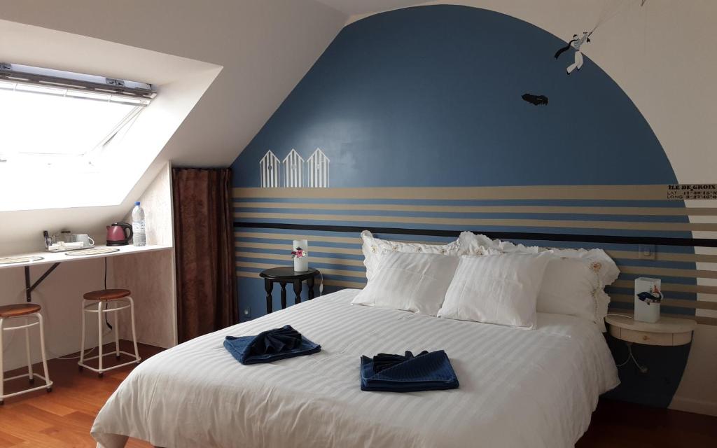 1 dormitorio con 1 cama blanca grande y paredes azules en Kerlobek Etoile en Groix