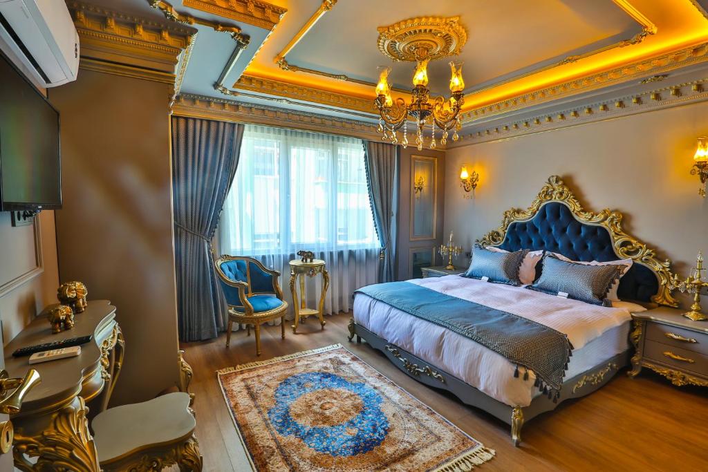 REAL KiNG SUiTE HOTEL في طرابزون: غرفة نوم بسرير كنج وثريا