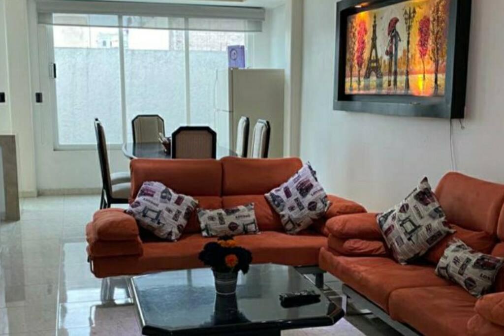 a living room with a couch and a glass table at Depa Frente al aeropuerto 8huespedes 103 in Mexico City