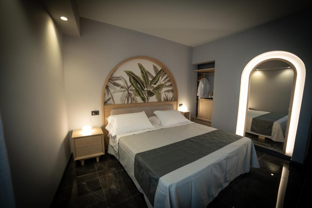 - une chambre avec un grand lit et deux miroirs dans l'établissement Ingrid Rooms Tropea, à Tropea