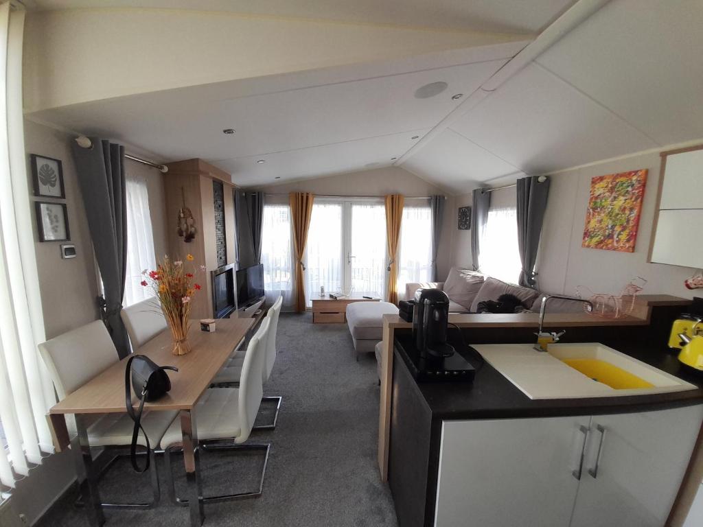 a living room with a kitchen and a living room with a couch at The Meadows New Beach Holiday Park in Kent