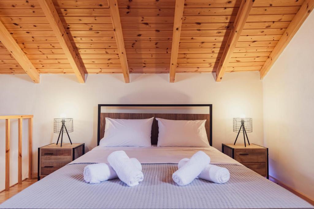 una camera da letto con un letto con due cuscini bianchi di Burnelia Vacation House a Lefkimmi