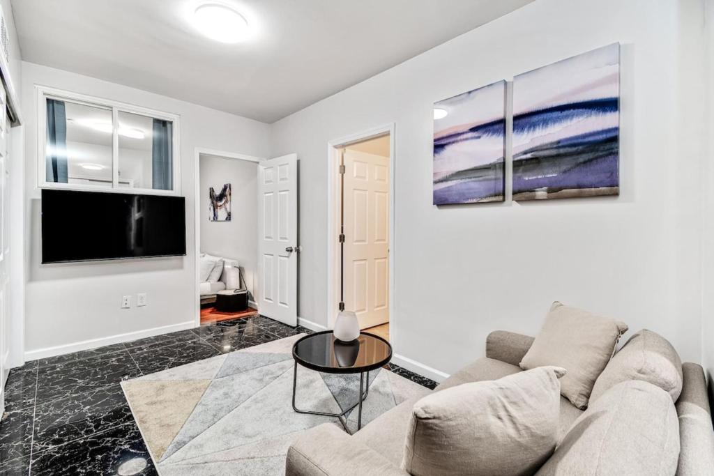 a living room with a couch and a tv at Cozy 1BD steps away from Convention Center in Philadelphia