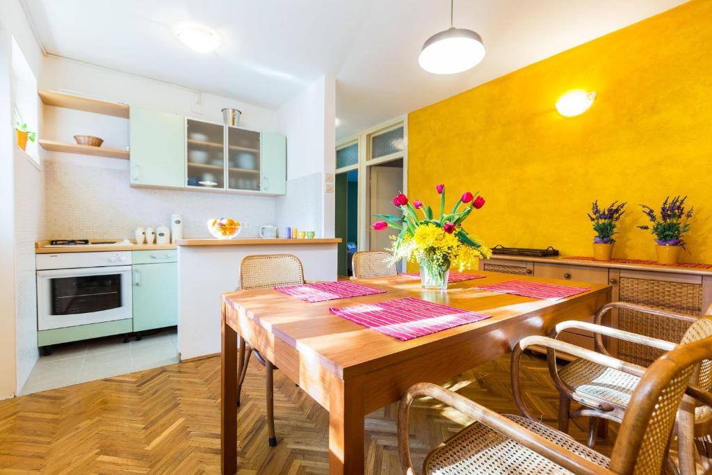 a kitchen and dining room with a wooden table and chairs at Lavender apt. w. balcony in old town in Zadar