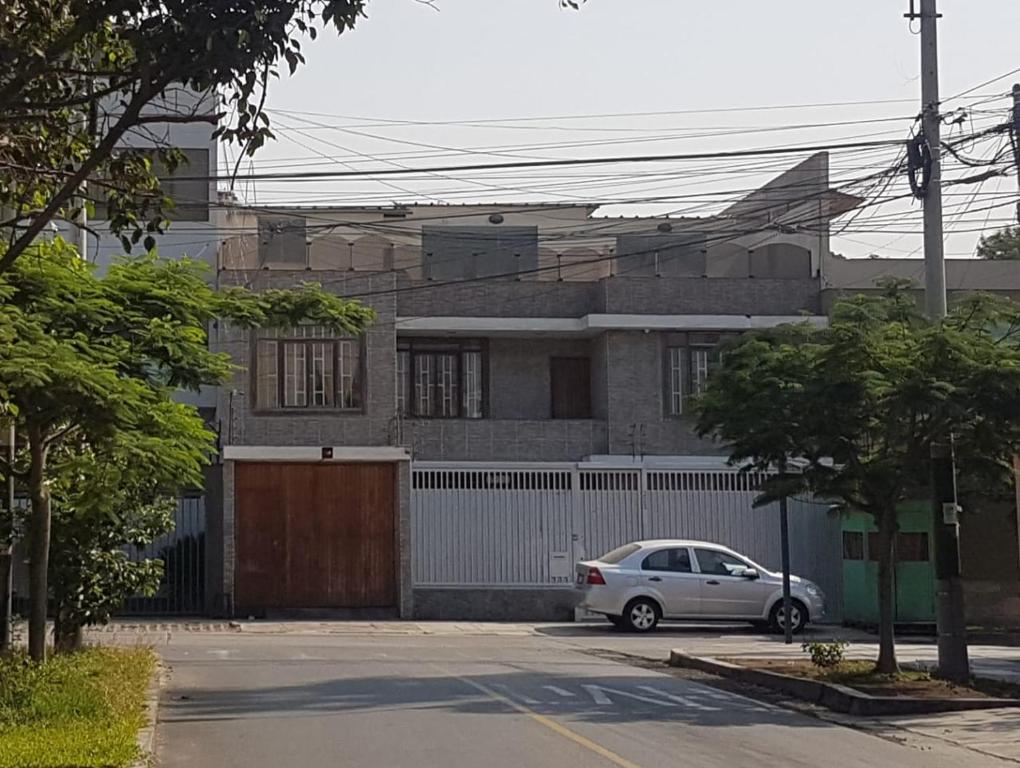une voiture blanche garée devant une maison dans l'établissement Casa Navarra, à Lima