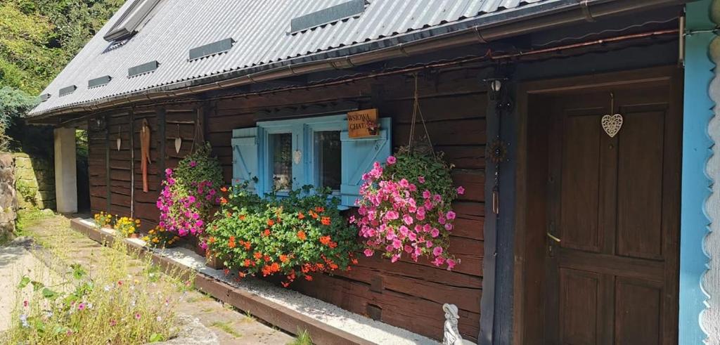 una casa con dei fiori sul lato di Wsiowa Chata a Ścinawka Górna