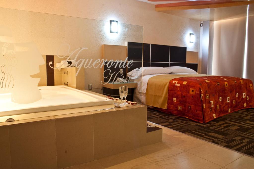 um quarto com uma banheira e uma cama e uma banheira em Hotel Aqueronte em Ixtapaluca